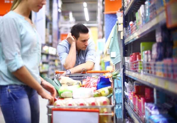 Discouraged couple shopping for groceries