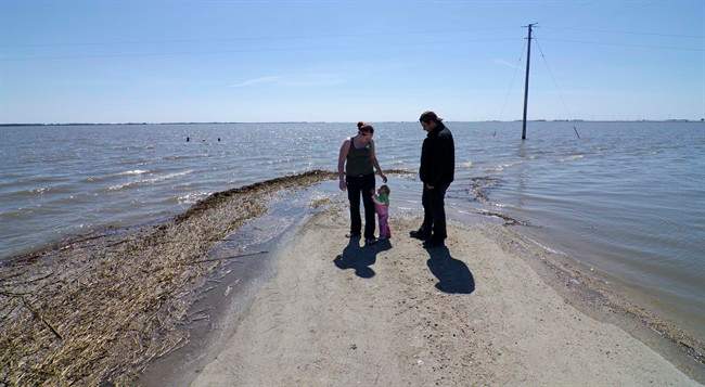 Reba Corrigan and Andy Krahn took their one-year-old daughter Page out to see the flood waters in Morris, Manitoba on Monday April 25, 2011 as the Red River and the Morris River remain at high levels. THE CANADIAN PRESS/David Lipnowski.