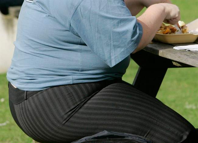 An overweight person eats in London, Eng., Wednesday, Oct. 17, 2007. A new report says getting physically active just 15 minutes a day would eliminate obesity in about one million Canadian adults. THE CANADIAN PRESS/AP-Kirsty Wigglesworth.