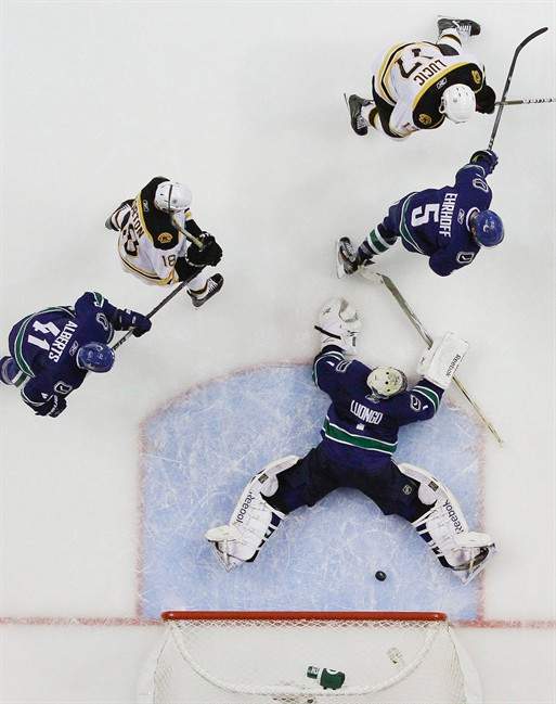 Boston Bruins left wing Milan Lucic (17) shoots the puck past Vancouver Canucks goalie Roberto Luongo (1) as Canucks Christian Ehrhoff (5) and defenseman Andrew Alberts (41) and Boston Bruins right wing Nathan Horton (18) look on in the second period during Game 2 of the NHL hockey Stanley Cup Finals, Saturday, June 4, 2011, in Vancouver, British Columbia. (AP Photo/Julie Jacobson).