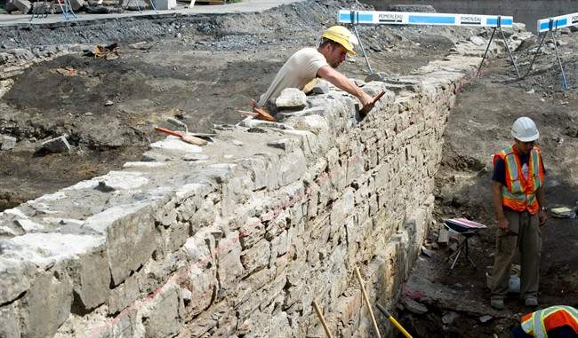 Archeologists dig in a parking lot in Old Montreal, Tuesday, July 12, 2011 hoping to uncover a piece of Canada's political past. They hope to find something from the remains of the first permanent parliament of what was then known as the United Province of Canada. THE CANADIAN PRESS/Paul Chiasson.