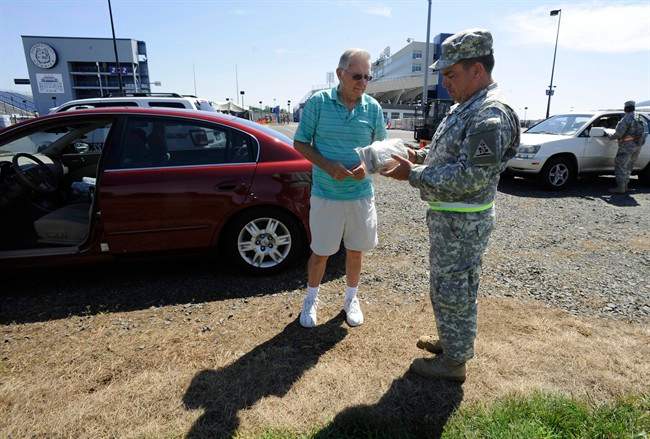 James LaFreniere of Chaplin, Conn., left, receives instructions on how to use an MRE (Meal Ready to Eat) from Sgt. First Class Chris Geist of the 102nd Army Band Unit of the Connecticut National Guard at Rentschler Field, in East Hartford, Conn., Wednesday, Aug. 31, 2011. National Guard troops unloaded food and water at the field for distribution to affected areas from Tropical Storm Irene. The University of Connecticut football team, which plays its home games at Rentschler field, had to postpone a season-opening game that had been scheduled against Fordham on Thursday because of the relief effort. (AP Photo/Jessica Hill).