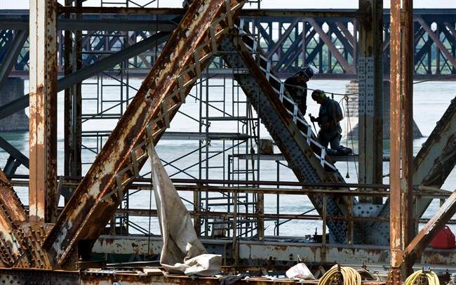 Workers repair the Mercier bridge which spans across the St Lawrence River Wednesday, August 3, 2011 in Montreal.