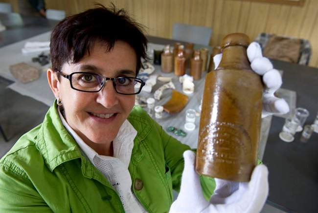 Louise Pothier, director of exhibitions at Montreal's Pointe-a-Calliere archeological and history museum, holds up a beer bottle found in the remains of what was supposed to have been the first permanent parliament of what was then the United Province of Canada, Monday, August 22, 2011 in Montreal. THE CANADIAN PRESS/Paul Chiasson.