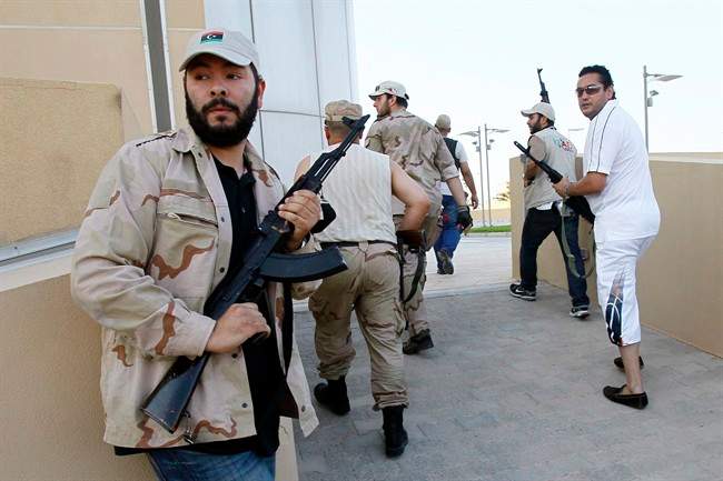 Libyan rebels patrol to try to find any of Moammar Gadhafi's relatives as they heard rumors that one of his sons was hiding inside a building, in Tripoli, Libya, Wednesday, Aug. 24, 2011. (AP Photo/Francois Mori).