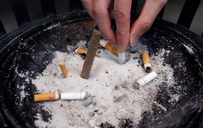A man puts out a cigarette.