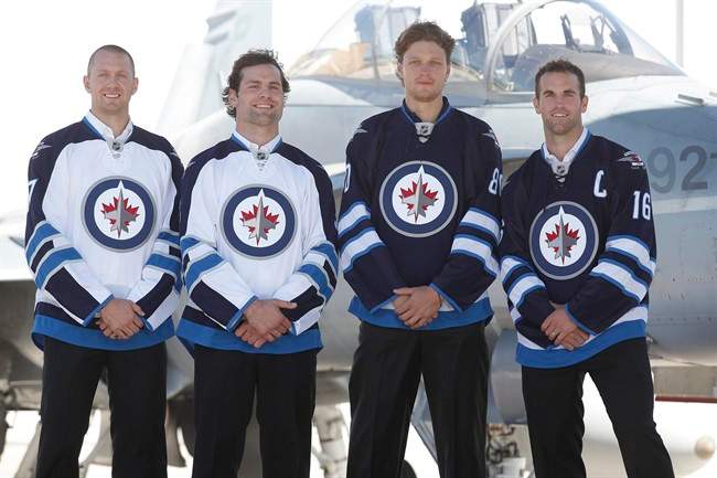 Winnipeg Jets Eric Fehr, left to right, Mark Stuart, Nik Antropov and Andrew Ladd poses for a photo in the new Jets jersey at a Canada Forces base in Winnipeg Tuesday, September 6, 2011. THE CANADIAN PRESS/John Woods.