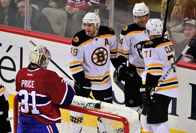 Boston Bruins' Chris Clark, right, celebrates his goal past Montreal Canadiens goalie Carey Price with teammates Rich Peverley, left, and Max Sauve during third period NHL pre-season hockey action Monday, September 26, 2011 in Montreal. The Bruins beat the Canadiens 2-1. THE CANADIAN PRESS/Paul Chiasson.