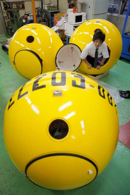A Cosmo Power Co. employee crawls out from a spherical earthquake and tsunami shelter "Noah" made of fiber enforced plastic at the company's factory in Hiratsuka, west of Tokyo, Friday, Sept. 30, 2011. The Japanese generator maker has developed a modern version of Noah's Ark in case Japan is hit by another massive earthquake and tsunami. The company of just 10 employees completed the first Noah, that has 1.2 meters (4 feet) in diameter and can hold up to four adults inside, earlier this month and already has 500 orders. (AP Photo/Itsuo Inouye).