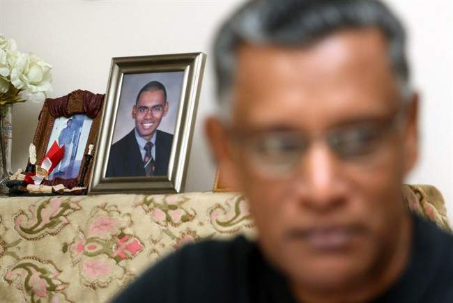 In this photo taken Friday, Sept. 9, 2011, with the backdrop of portraits of the 9/11 terrorist attacks' victim Vijayashanker Paramsothy, his father Paramsothy Sivapakiam, 60, speaks during an interview in Petaling Jaya, near Kuala Lumpur, Malaysia. Sivapakiam said he had to learn to deal with burning hatred and anger against the terrorists who took his son's life. (AP Photo/Lai Seng Sin).