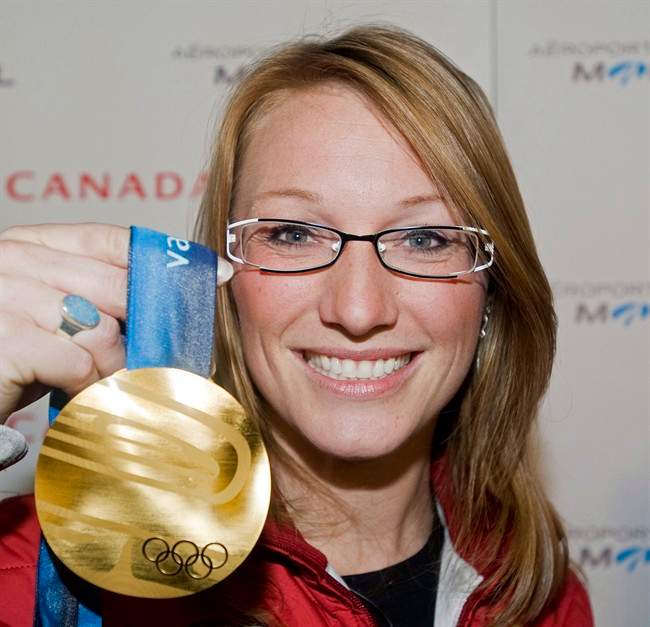 Canadian bobsledder Heather Moyse holds up her gold medal at Trudeau airport in Montreal, Monday, March 1, 2010, following her arrival from the Vancouver 2010 Olympic Winter games. Moyse is looking to score in a third sport.The 33-year-old from Summerside, P.E.I, who also plays for the Canadian women's rugby team, is turning her attention to track cycling. 