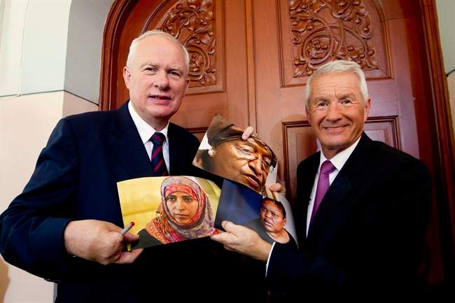 Norwegian Nobel Committee chairman Thorbjoern Jagland, right, and Permanent Secretary Geir Lundestad, left, hold up photographs of Liberian President Ellen Johnson Sirleaf, center top, Liberian peace activist Leymah Gbowee, center right, and Tawakkul Karman of Yemen, center left, after announcing them as the recipients of the 2011 Nobel Peace prize in Oslo, Norway, Friday, Oct. 7, 2011. The 2011 Nobel Peace Prize was awarded Friday to Liberian President Ellen Johnson Sirleaf, Liberian peace activist Leymah Gbowee and Tawakkul Karman of Yemen for their work on women's rights. (AP Photo/Scanpix Norway, Terje Bendiksby) NORWAY OUT.