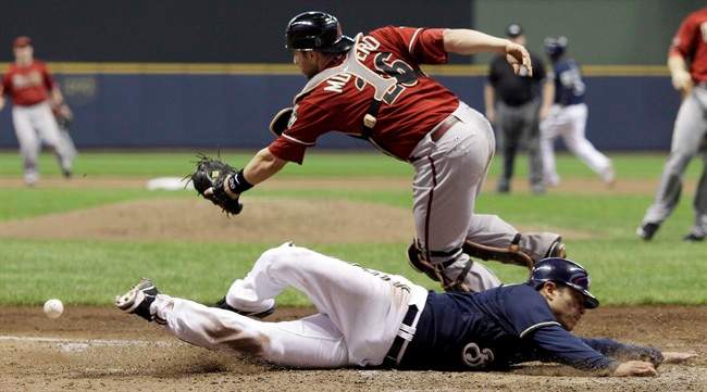 Arizona Diamondbacks catcher Miguel Montero can't catch the throw as Milwaukee Brewers' Jerry Hairston Jr. scores from third on a squeeze bunt by Jonathan Lucroy during the sixth inning of Game 2 of baseball's National League division series Sunday, Oct. 2, 2011, in Milwaukee. (AP Photo/David J. Phillip).