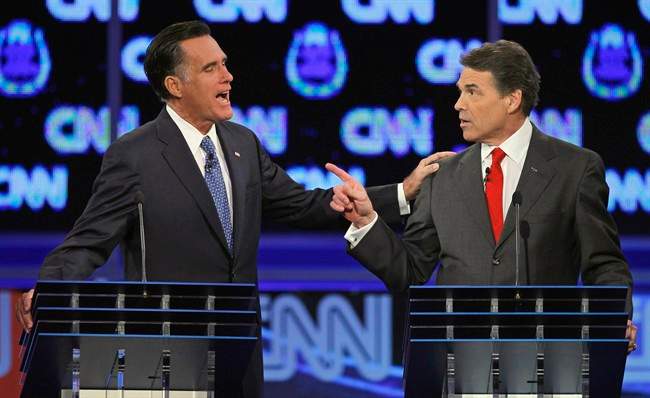 FILE - In this Oct. 18, 2011 file photo, Republican presidential candidates, former Massachusetts Gov. Mitt Romney, left, and Texas Gov. Rick Perry, speak during a Republican presidential debate in Las Vegas. The image of Romney laying a hand on Perry's shoulder may well be remembered long after people have forgotten that the two were squabbling about. Body language speaks volumes in political debates. (AP Photo/Chris Carlson, File).