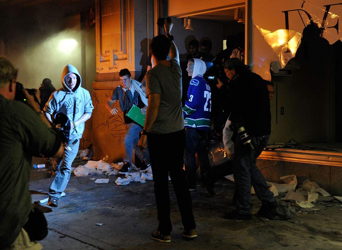 People run out of a Hudson Bay Co store with merchandise on June 15, 2011 in Vancouver, Canada. Vancouver broke out in riots after their hockey team the Vancouver Canucks lost in Game Seven of the Stanley Cup Finals.  