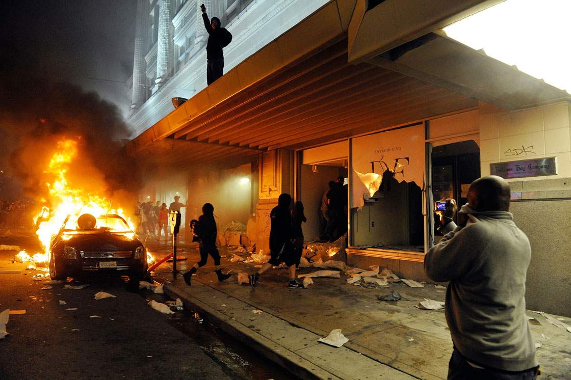 People take pictures of a burning vehicle on June 15, 2011 in Vancouver, Canada. Vancouver broke out in riots after their hockey team the Vancouver Canucks lost in Game Seven of the Stanley Cup Finals.  