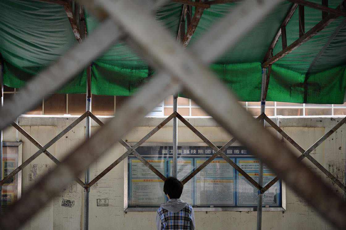 A young man reads a bulletin board at a Foxconn recruitment center in Shenzhen, south China's Guangdong province. 