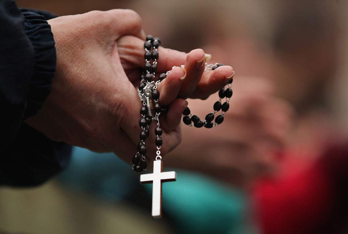 A rosary is held.