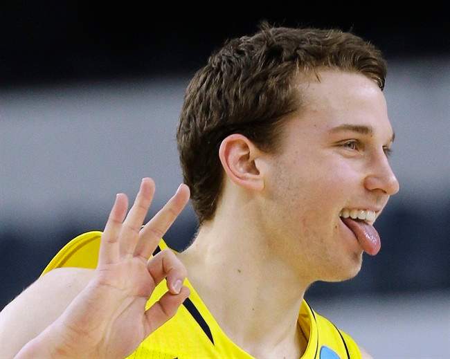 Michigan guard Nik Stauskas reacts after making a 3-point shot against Florida during the first half of a regional final game in the NCAA college basketball tournament, Sunday, March 31, 2013, in Arlington, Texas.