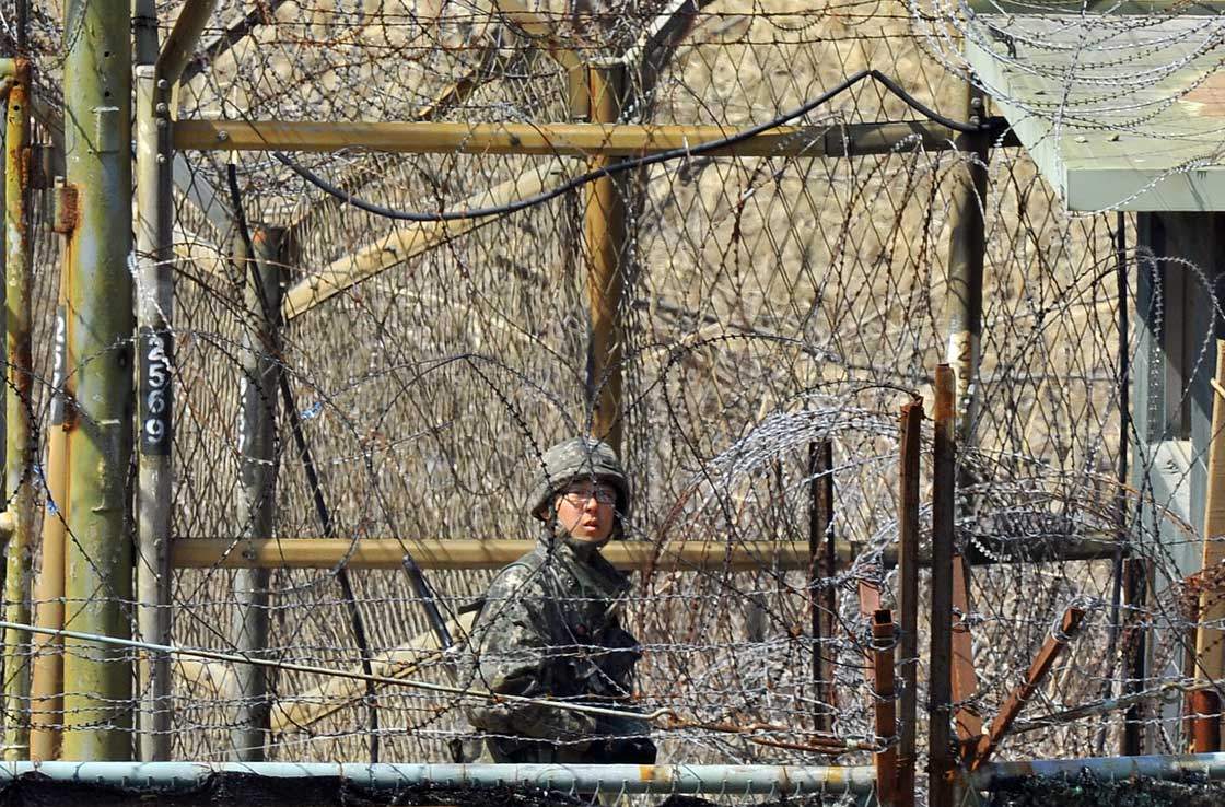 A South Korean soldier looks over barbed-wire from a military guard area near the demilitarized zone dividing the two Koreas in the border city of Paju on March 27, 2013.  