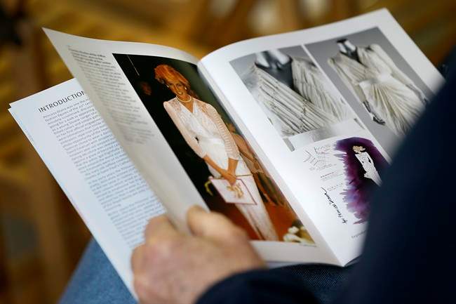 An auction attendee reads the catalogue ahead of the Kerry Taylor 'Fit for a Princess' auction in London, Tuesday, March 19, 2013. The auction was of ten dresses formerly owned and worn by Britain's Princess Diana. The total hammer price for the ten lots was 719,000 pounds ($1.09 million US) not including the 20 percent buyers premium .