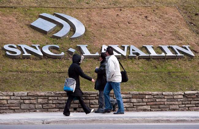 Pedestrians walk past the offices of SNC Lavalin, in Montreal, March 26, 2012.
