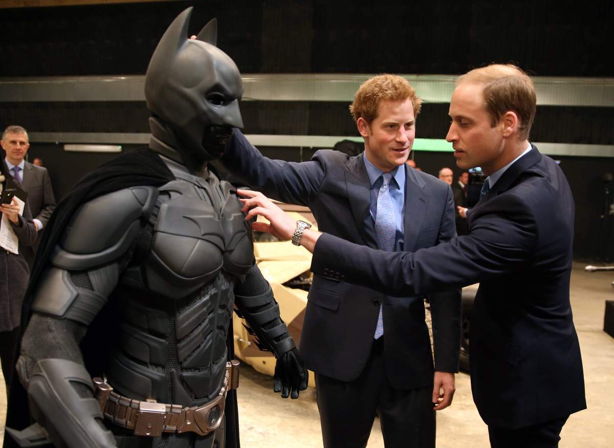 Britain’s Prince William, right, and his brother Prince Harry look at a ‘Batsuit’ used in the Batman films. (AP Photo/Chris Jackson, Pool)