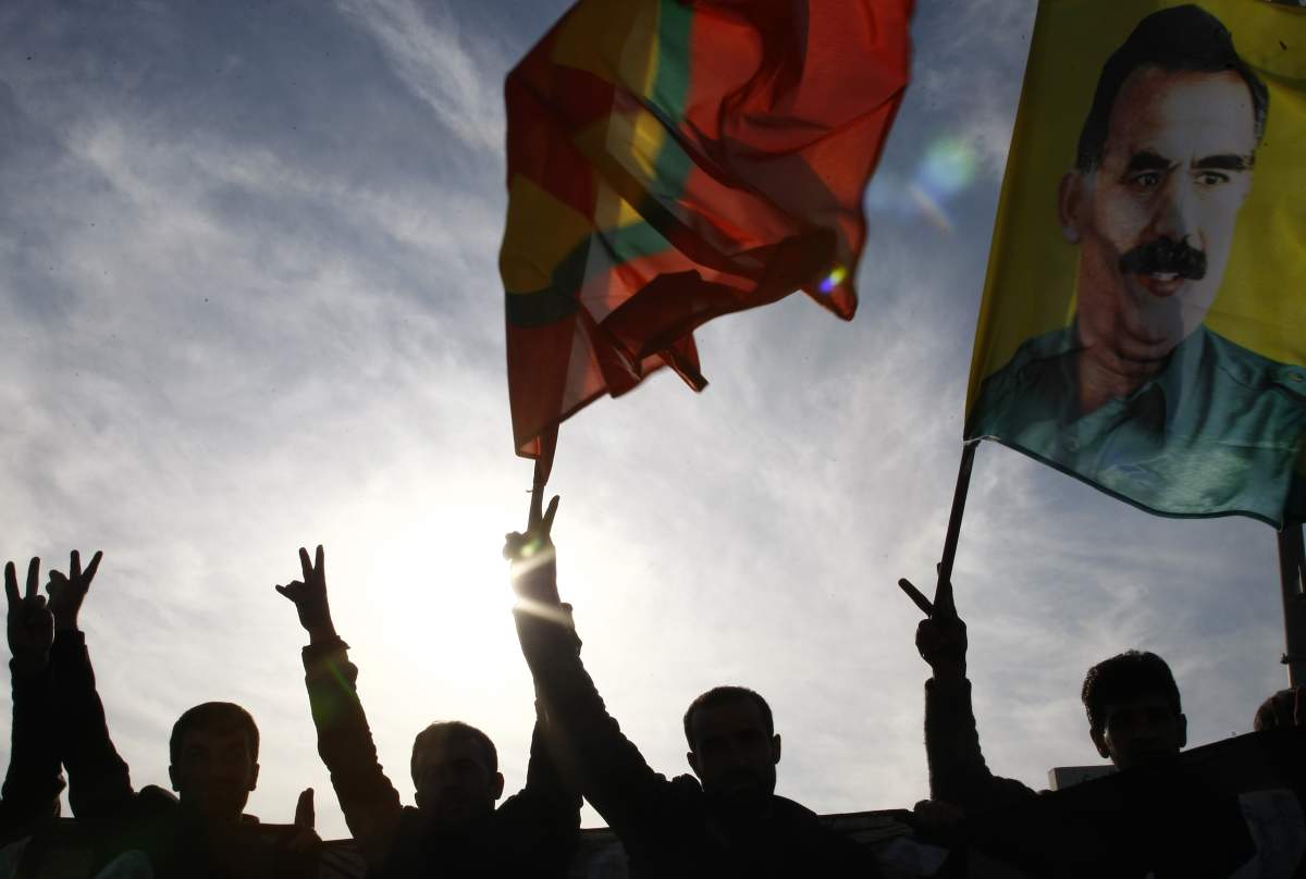 Kurdish demonstrators hold up flags as they protest in Arbil on December 30, 2011 .