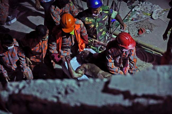 Bangladeshi soldiers and firefighters carry a burned and injured colleague after a fire in a tunnel that rescue workers were using to search for survivors in a building that collapsed Wednesday in Savar, near Dhaka, Bangladesh, Sunday, April 28, 2013.