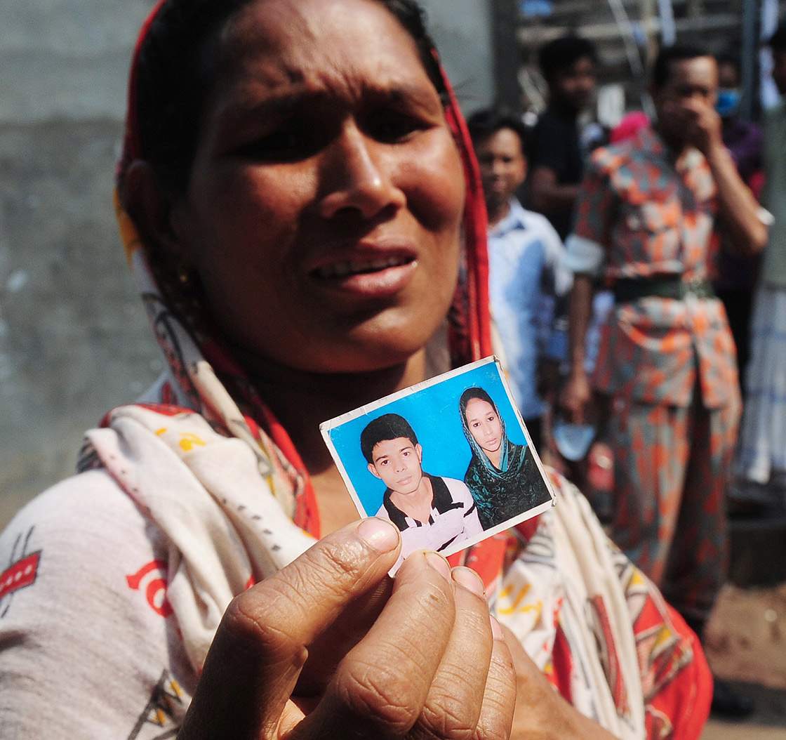 A Bangladeshi woman shows a portrait of her missing son, believed trapped in the rubble.  (Getty Images)