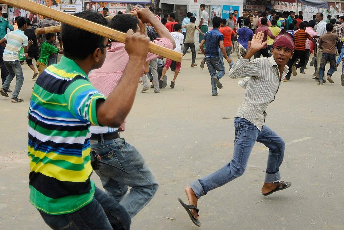 Plain-clothed Bangladeshi police brandish sticks as they attempt to break up demonstrating garment workers following the collapse of an eight-storey building, in Dhaka on April 26, 2013.  (Getty Images)