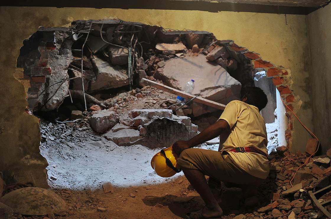 A Bangladeshi volunteer cautiously looks through an opening in a wall as he looks for survivors in the rubble 48 hours after an eight-storey building collapsed in Savar, on the outskirts of Dhaka, on April 26, 2013.  (Getty Images)