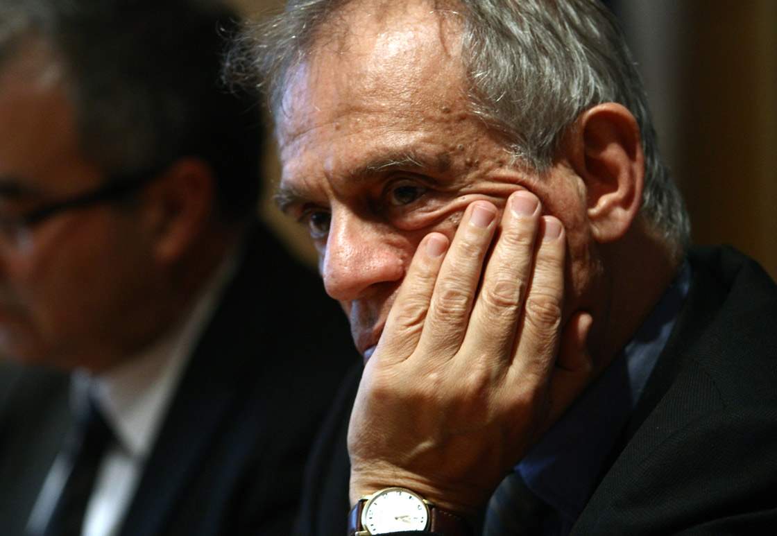 Finance Minister Michalis Sarris listens on during a joint press conference with Central Bank Governor Panicos Demetriades in Nicosia on March 26, 2013.