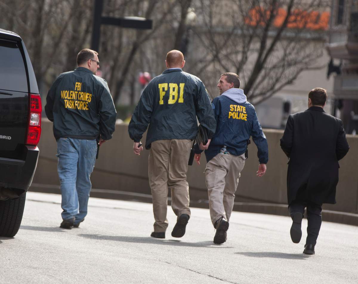 FBI and State Police officers arrive at the scene on St. James Street after multiple explosions went off on Boylston Street near the finish line of the Boston Marathon on Monday, April 15, 2013. 