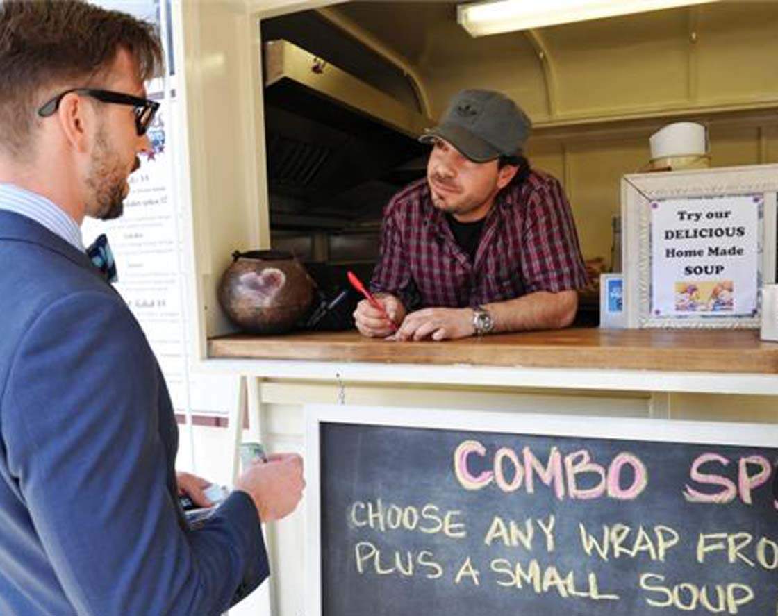 Mark Cohen of Mangal Kiss Mid-Eastern BBQ helps a customer Thursday on West Georgia Street in downtown Vancouver.