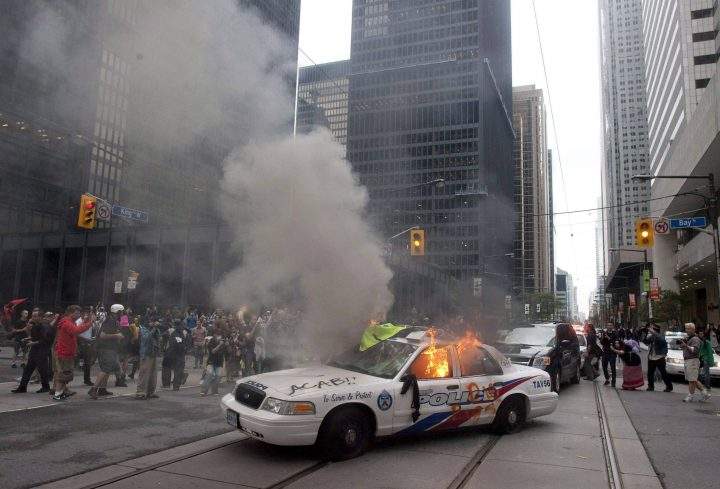 A police car burns after G20 summit protesters set fire to it in downtown Toronto on Saturday, June 26, 2010.