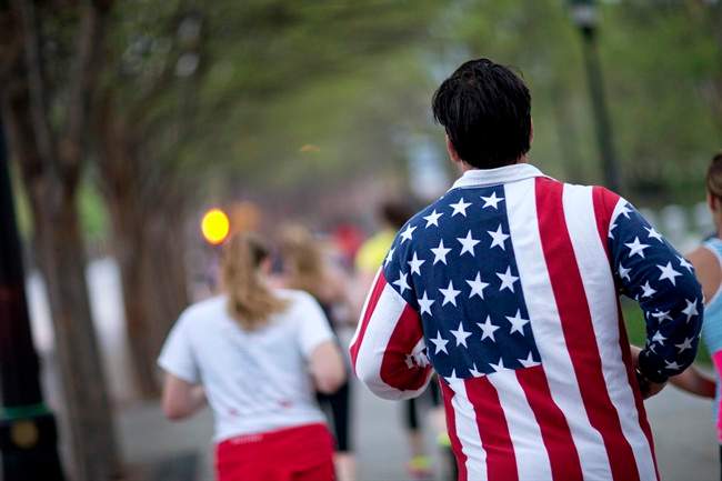 Conn Jackson, of Atlanta, right, wears a shirt decorated with the flag of the United States as he takes part in an organized moment of silence and memorial run to show solidarity with victims of the Boston Marathon bombing, Tuesday, April 16, 2013, in Atlanta. (AP Photo/David Goldman).