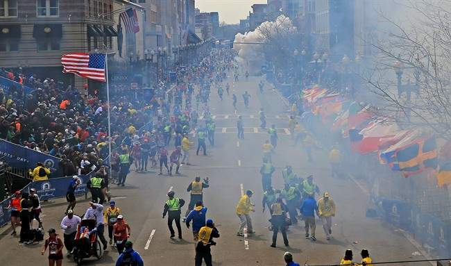 People react as an explosion goes off near the finish line of the 2013 Boston Marathon in Boston, Monday, April 15, 2013. (AP Photo/The Boston Globe, David L Ryan)