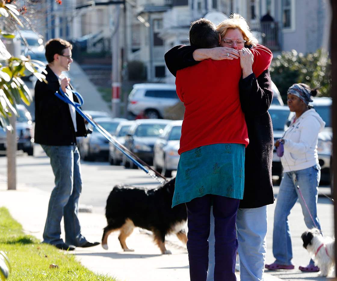 Neighbors hug outside the home of the Richard family in the Dorchester neighborhood of Boston, Tuesday, April 16, 2013.
