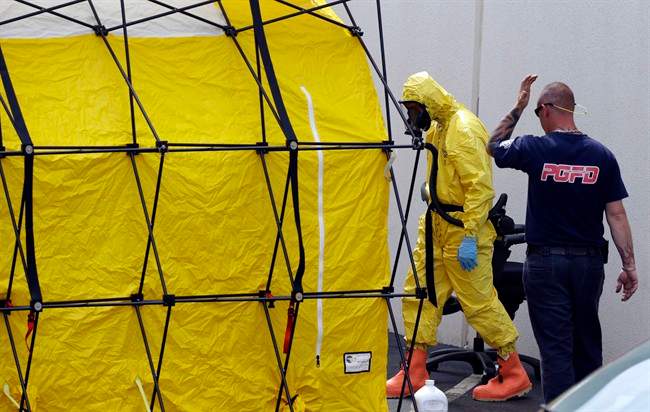 A Prince George's County, Md. firefighter dressed in a protective suit walks out of a government mail screening facility in Hyattsville, Md., Wednesday, April 17, 2013. Police swept across the U.S. Capitol complex to chase a flurry of reports of suspicious packages and envelopes Wednesday after preliminary tests indicated poisonous ricin in two letters sent to President Barack Obama and a Mississippi senator. (AP Photo/Alex Brandon).