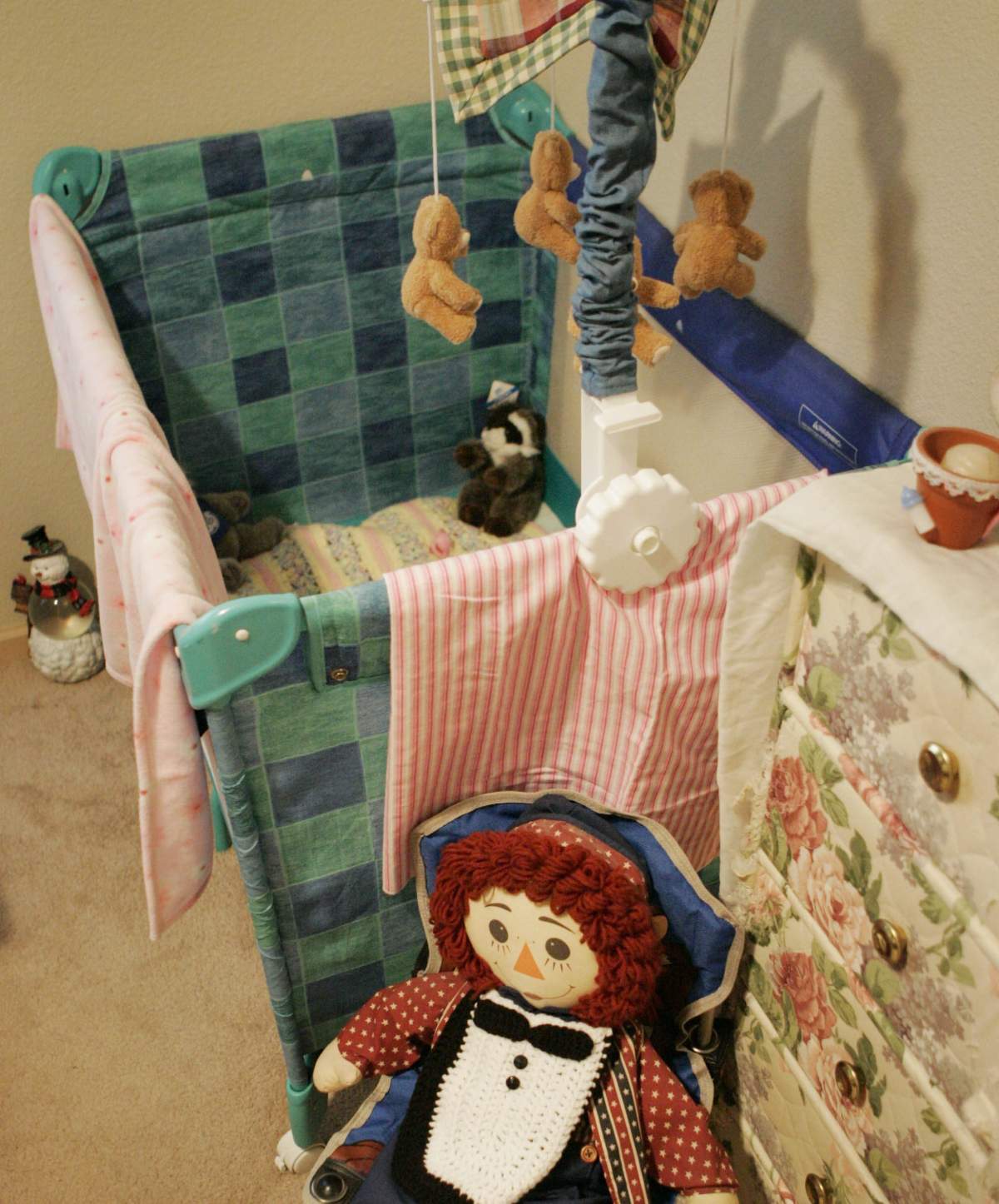 A playpen stands empty in a nursery.