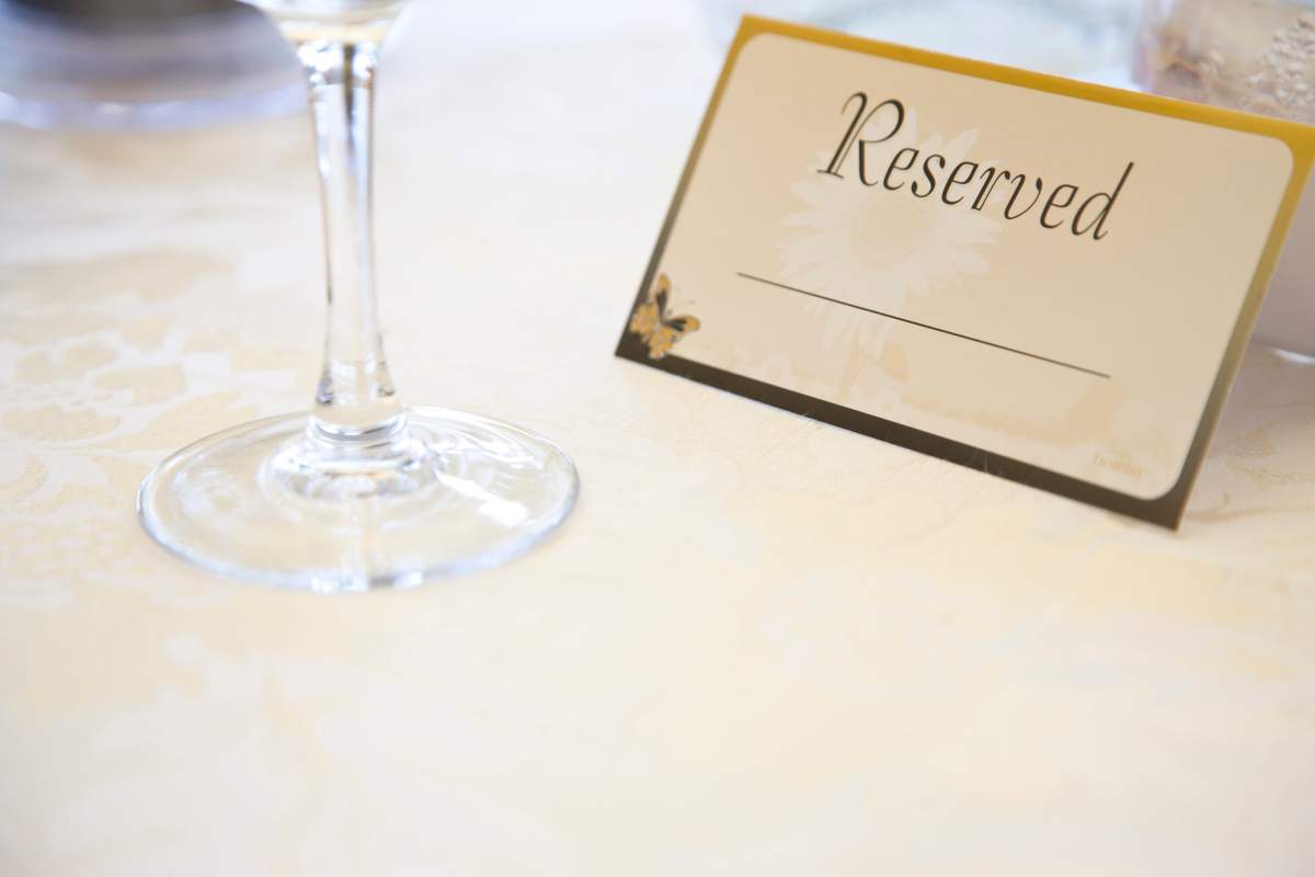 Place setting and reserved sign on restaurant table.
