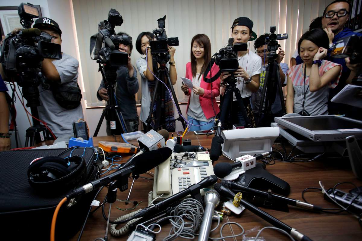 Reporters crowd around a speakerphone as they listen to a transgender woman on it after she won a legal ruling at Hong Kongs top court allowing her to marry, in Hong Kong Monday, May, 13, 2013. 