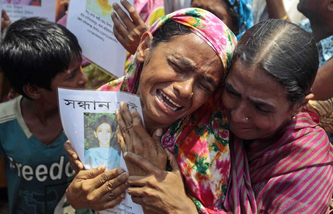 A Bangladeshi woman cries holding the portrait of a missing relative as they gather to offer prayers for the souls of the 1,127 people who died in the garment building structure collapse last month, in Savar, near Bangladesh, Tuesday, May 14, 2013.