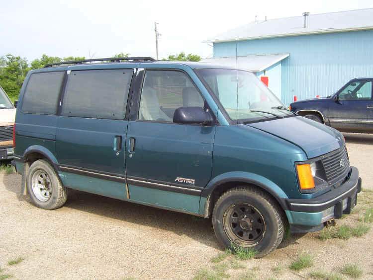 The van has a cream-coloured passenger door and the window is missing from the rear passenger door.
