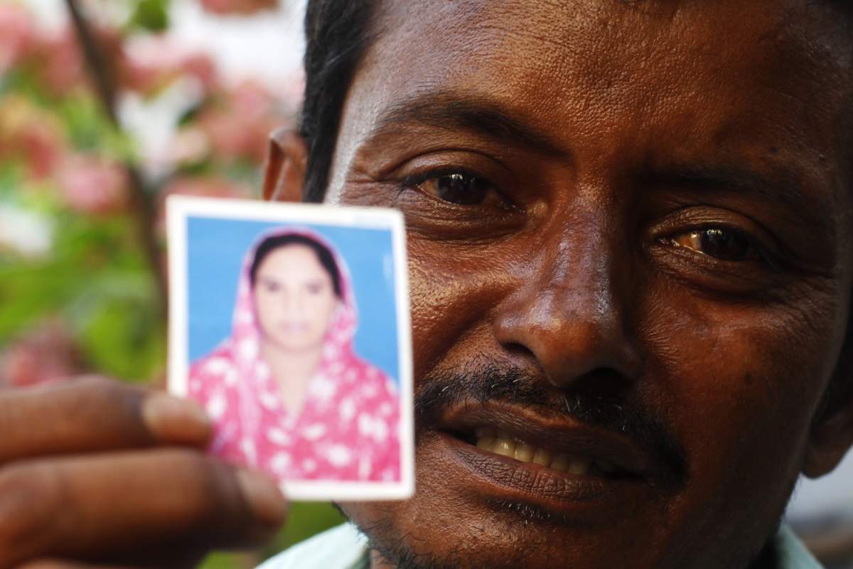 A Bangladeshi relative of a garment worker holds up a portrait of a missing relative in the Dhaka medical hospital in Dhaka on May 2 ,2013. (STRDEL/AFP/Getty Images).
