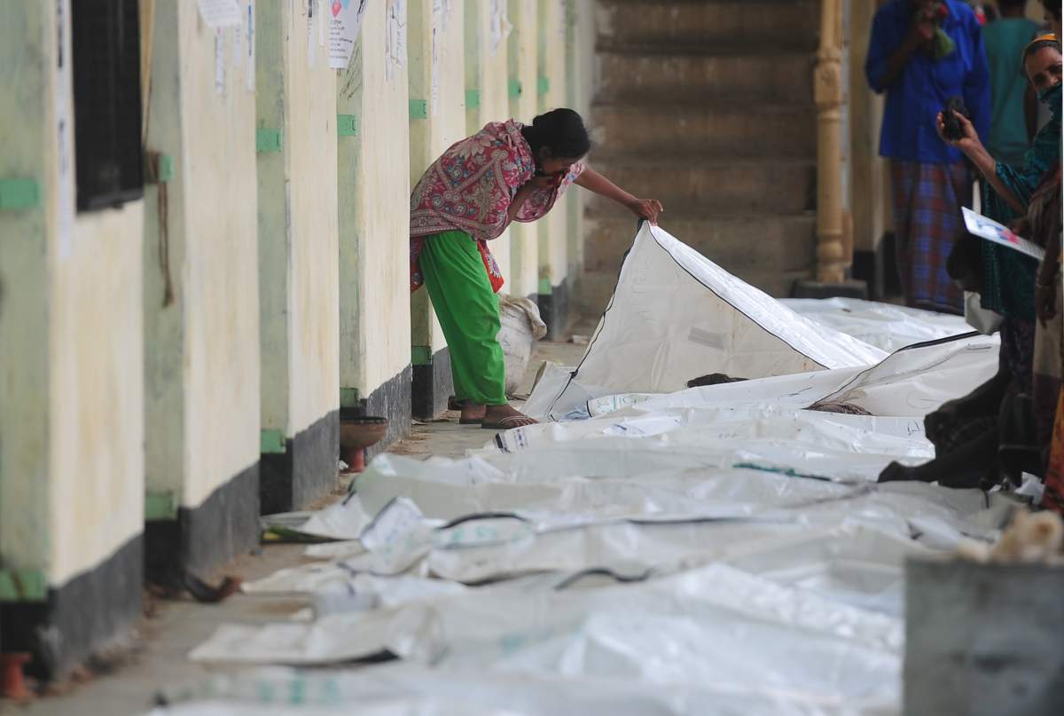 A Bangladeshi relative attempts to identify the bodies of loved ones killed in building collapse in Savar, on the outskirts of Dhaka on May 10, 2013. 