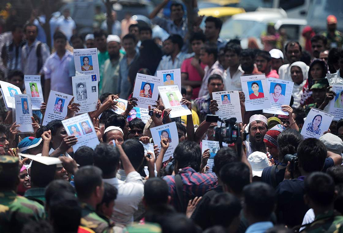 Bangladeshi family members hold up portraits of missing relatives as they march demanding the wages of missing workers and the death sentence for the building owner, at the nine-storey building collapse in Savar, on the outskirts of Dhaka on May 14, 2013.