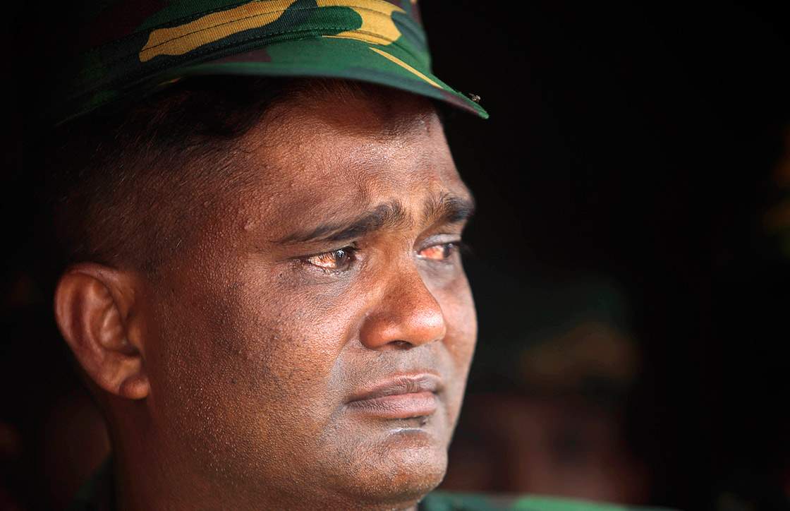 A Bangladesh army soldier cries he offers prayers for the souls of the 1,127 people who died in the garment building structure collapse last month, in Savar, near Bangladesh, Tuesday, May 14, 2013.