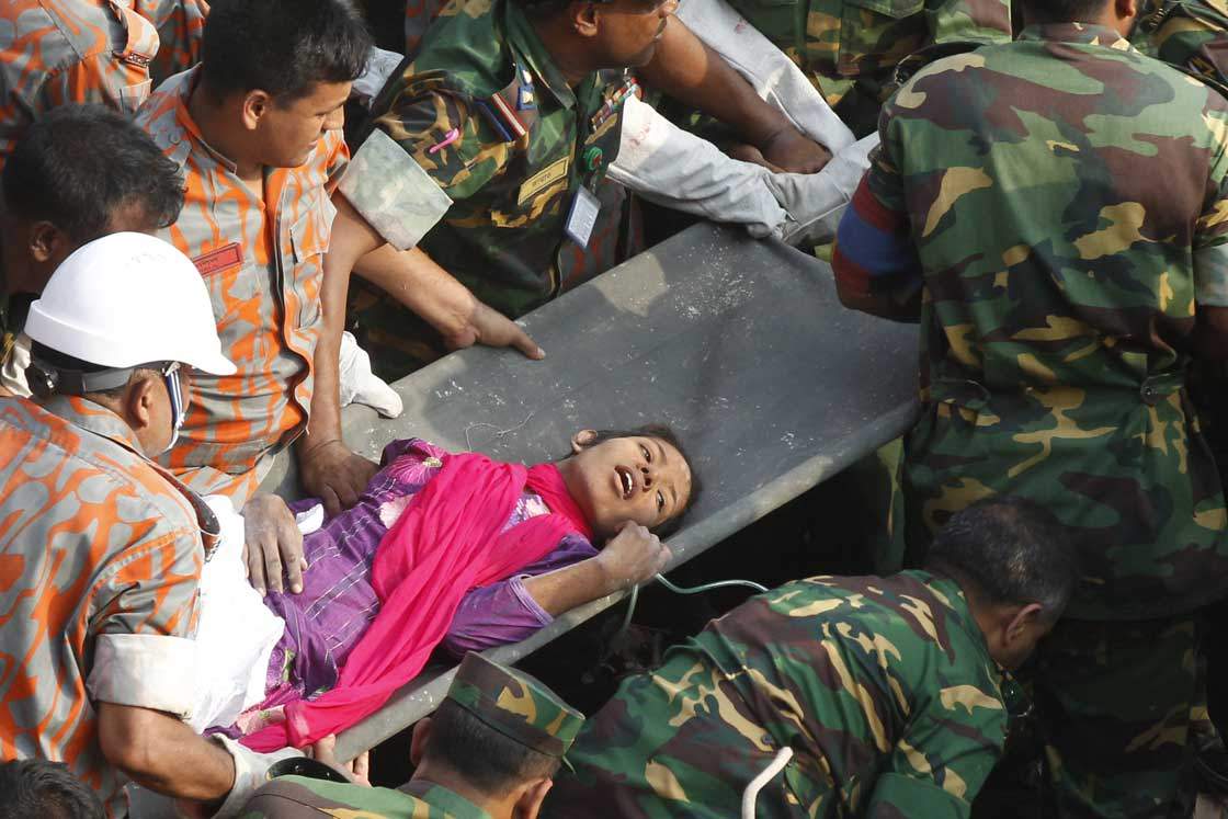 Bangladeshi workers rescue garment worker Reshma from the rubble of a collapsed building in Savar on May 10, 2013, 17 days after the eight-story building collapsed.